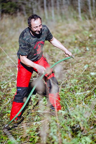 Manfred zeigt beim Biodiversitätsaktionstag, wie man die Waldwiesen mit der Sense mäht